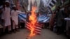 Supporters of the Jamaat-ud-Dawa Islamic organiztion burn a mock U.S. flag during a protest in Peshawar, Pakistan, May 27, 2016.