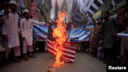 Supporters of the Jamaat-ud-Dawa Islamic organiztion burn a mock U.S. flag during a protest in Peshawar, Pakistan, May 27, 2016.