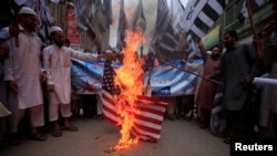 FILE - Supporters of the Jamaat-ud-Dawa Islamic organization burn a mock U.S. flag during a protest in Peshawar, Pakistan, May 27, 2016.