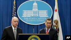 California Gov. Jerry Brown (L), accompanied by California Attorney General Xavier Becerra, listens to a question concerning remarks made U.S. Attorney General Jeff Sessions, March 7, 2018, in Sacramento, California.