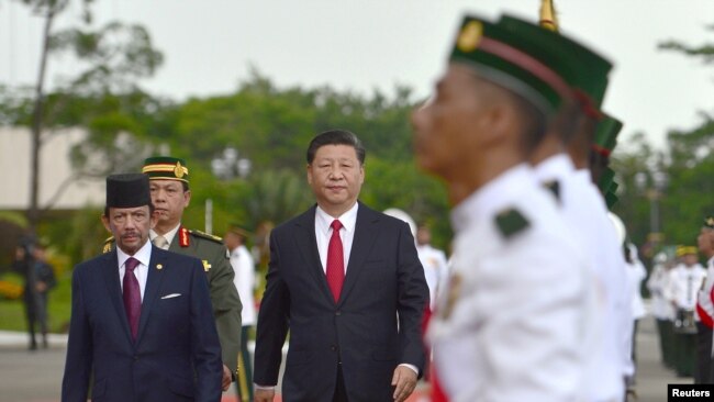中国国家主席习近平和文莱元首哈桑纳尔苏丹的陪同下检阅文莱仪仗队。（2018年11月19日）