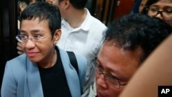 Maria Ressa (kiri) tampak dikawal oleh agen Biro Penyelidik Federal hari Rabu (13/2).