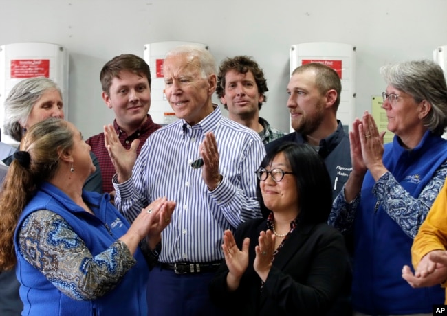 Former vice president and Democratic presidential candidate Joe Biden, center, is applauded as he speaks during a tour at the Plymouth Area Renewable Energy Initiative in Plymouth, N.H., June 4, 2019.