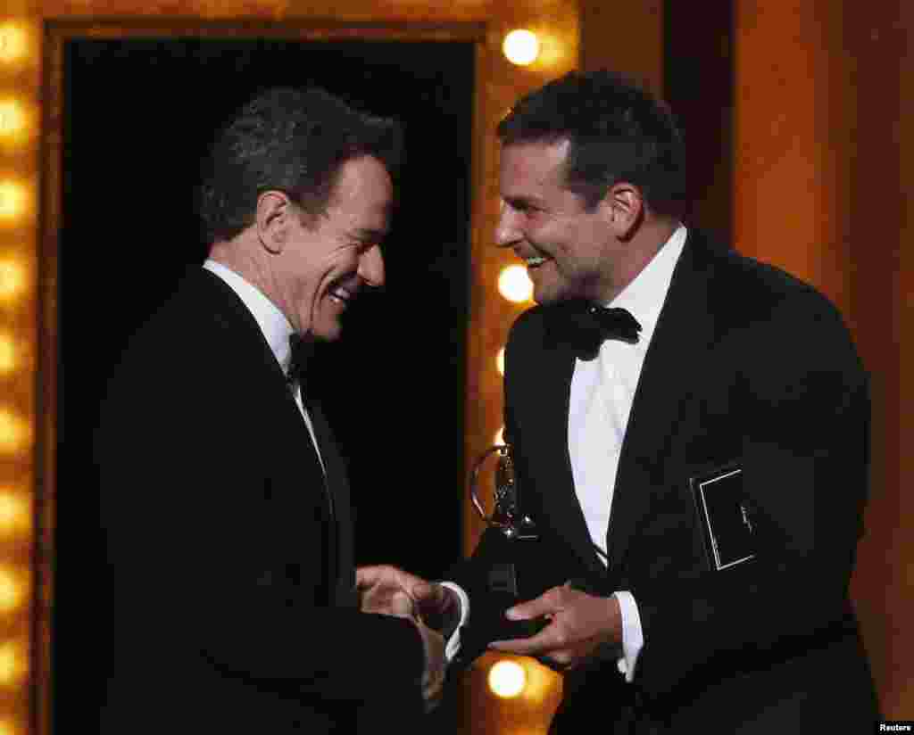 Bradley Cooper (kanan) menyerahkan piala Tony untuk Bryan Cranston, pemeran utama pria terbaik dalam &quot;All The Way&quot; pada malam anugerah untuk insan teater Amerika &quot;Tony Awards&quot; di Radio City Music Hall, New York (8/6).