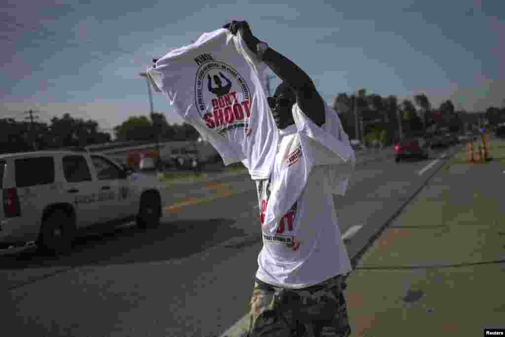 Um homem vende t-shirts ao longo da estrada em Ferguson, Missouri, Ago. 21, 2014.