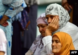 Bosnian Muslim women are seen while people gather in front of the central mosque in Srebrenica to pay last respects to late Hatidza Mehmedovic, July 25, 2018.