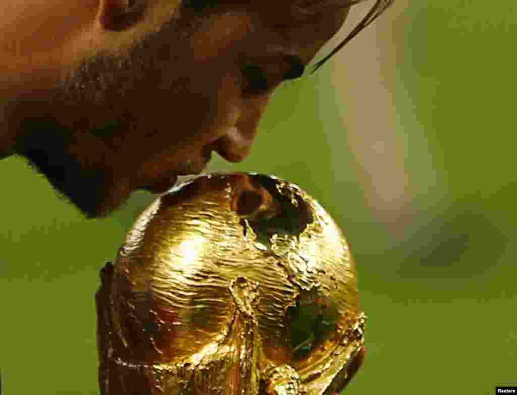 Germany's Mario Goetze kisses the World Cup trophy at the Maracana stadium in Rio de Janeiro ,July 13, 2014. 