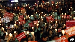South Korean protesters hold candles during a rally against a Free Trade Agreement (FTA) between South Korea and the United States in Seoul, South Korea, Nov. 5, 2011.