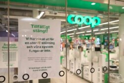 Sebuah tanda bertuliskan "Tutup Sementara. Kami mengalami gangguan TI dan sistem kami tidak berfungsi", dipasang di jendela toko supermarket Coop yang tutup di Stockholm, Swedia, 3 Juli 2021.
