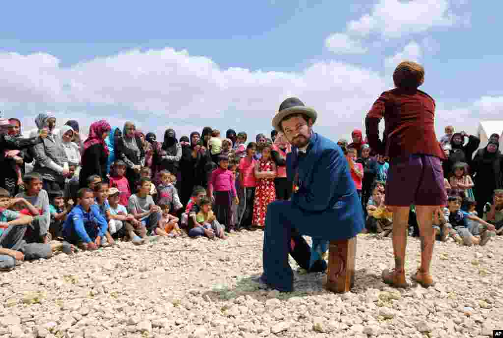Members of "Clowns Without Borders," perform for children at a Syrian refugee camp in the eastern town of Chtoura, in Bekaa valley, Lebanon, June 6, 2014.