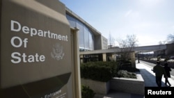 FILE - People enter the State Department building in Washington, Jan. 26, 2017.