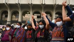 Mujeres guatemaltecas Achi, víctimas de violencia sexual durante el conflicto armado interno (1960-1996), reaccionan al final del juicio contra cinco exmiembros de la Patrulla Civil Guatemalteca (PAC), frente al Palacio de Justicia de Guatemala, el 24 de enero de 2022.