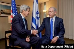 U.S. Secretary of State John Kerry shakes hands with Israeli Prime Minister Benjamin Netanyahu after they address the media before holding a bilateral meeting in Berlin, Germany, Oct. 22, 2015.