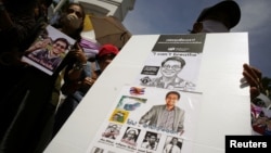 Activists hold up pictures of abducted Thai activist Wanchalearm Satsaksit as people gather in support of him during a protest calling for an investigation, in front of the Government House in Bangkok, Thailand, June 12, 2020. (REUTERS/Athit Perawongmetha)