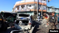 Afghan security forces inspect the site of a suicide attack in Jalalabad, Afghanistan, March 7, 2018. 