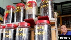 A coffee seller displays coffee beans for sale at a shop in Hanoi, August 13, 2013.