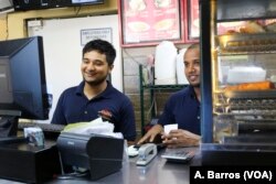 Employees tend to customers at Aladdin Sweets & Cafe in Banglatown, Hamtramck, Michigan.