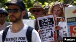 FILE - Protesters react as they hold placards and listen to speakers during a rally in support of refugees in central Sydney, Australia, Oct. 19, 2015. 