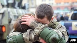 Seorang polisi Ukraina memeluk istrinya dalam sebuah upacara di Kharkiv, Ukraina, sebelum keberangkatannya ke wilayah timur negara itu untuk berperang, setelah gagalnya perundingan perdamaian antara Kyiv dan separatis pro-Rusia.