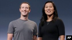 FILE - Facebook CEO Mark Zuckerberg and his wife, Priscilla Chan, smile as they prepare for a speech in San Francisco. 