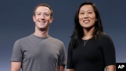 FILE - Facebook CEO Mark Zuckerberg and his wife, Priscilla Chan, smile as they prepare for a speech in San Francisco. 
