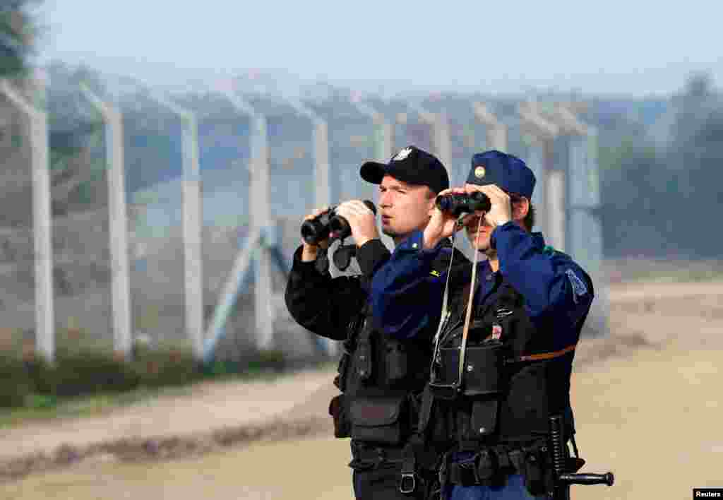 Hungarian and Polish policeman patrol at the Hungary and Serbia border fence near the village of Asotthalom, Oct. 2, 2016 as Hungarians vote in a referendum on the European Union&#39;s migrant quotas.