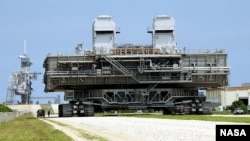 A mobile launch platform is taken to the launch pad by a NASA crawler-transporter.