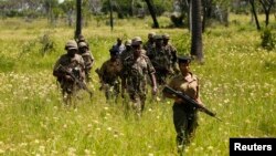 Kenyan police officers patrol Mavuno villages near Mpeketoni after unidentified gunmen recently attacked the coastal Kenyan town of Mpeketoni, June 17, 2014.