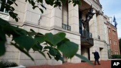 A security guard walks by the front of federal court as jury deliberations begin in the trial of the former Trump campaign chairman, in Alexandria, Virginia, Aug. 16, 2018. 