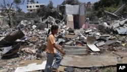 星期五在加沙城的一名女孩走過以色列空襲後的房屋廢墟