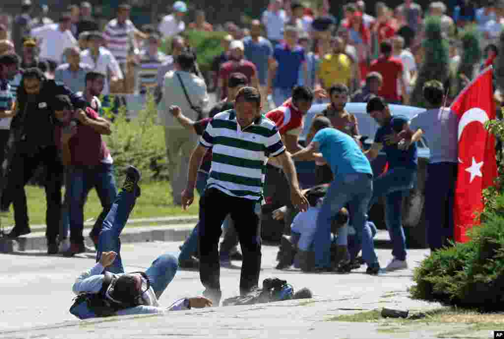 Supporters of Turkey's President Recep Tayyip Erdogan, who were staging a protest against a coup, clash with Turkish journalists near the Turkish military headquarters, in Ankara, Turkey, July 16, 2016. 