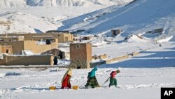 Afghan women drag containers of water on the outskirts of Kabul, Jan. 9, 2014. 