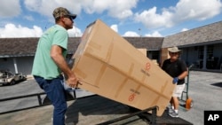 Volunteer Danny Floyd, right, of Weatherford, Okla,, helps Kenny Smallwood load new furniture donated by the nation's Churches of Christ, at Outdoor Resorts of Chokoloskee, in Chokoloskee, Fla., Nov. 9, 2017. Kenny and Brittany Smallwood say FEMA rejected their assistance request after an eight-minute inspection, even though Hurricane Irma's torrential rains poured through the hole it tore in their home's roof, causing extensive damage. They say they were denied financial aid because one room remains livable. They share it with their three young sons.