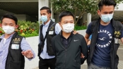 Ryan Law, second from right, Apple Daily's chief editor, is arrested by police officers in Hong Kong Thursday, June 17, 2021. Hong Kong police on Thursday morning arrested the chief editor and four other senior executives of Apple Daily