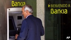 Un cliente de Bankia usa un cajero automático en Madrid. Bankia arrastró las bolsas europeas a niveles récord.