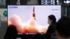 People watch a TV showing an image of North Korea's new guided missile during a news program at the Suseo Railway Station in Seoul, South Korea, Friday. March 26, 2021.
