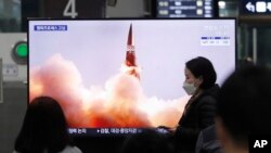 People watch a TV showing an image of North Korea's new guided missile during a news program at the Suseo Railway Station in Seoul, South Korea, Friday. March 26, 2021.