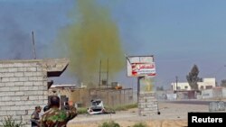 FILE - A chlorine-tinged cloud of smoke rises into the air from an Islamic State bomb that was detonated by Iraqi army and Shi'ite fighters in the town of al-Alam in Salahuddin province, Iraq, March 10, 2015.