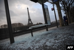 A picture taken in Paris, Dec. 9, 2018, shows a broken bus stop and (background) the Eiffel tower a day after a "yellow vest" protests as part of a fourth weekend of nationwide protests.