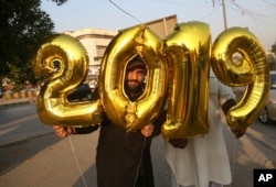 Pakistani vendors sell balloons on New Year's Eve, in Karachi, Pakistan, Monday, Dec. 31, 2018. (AP Photo/Shakil Adil)