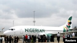 FILE - Journalists gather next to a Nigerian Eagle Airlines plane during its launch in Nigeria's commercial capital of Lagos, Sept. 18, 2009.