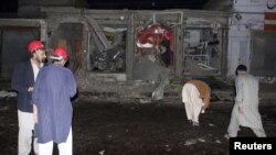 Rescue workers and security officials stand at the site of a suicide bomb attack on the outskirts of Rawalpindi near Islamabad, November 21, 2012.