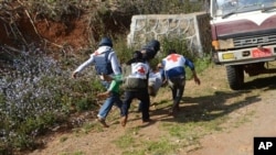 In this Feb. 17, 2015, photo provided by the Eleven Media Group, Myanmar red-cross members carry an injured victim during a clash between government troops and Kokang rebels in Kokang, northeastern Shan State, more than 800 kilometers (500 miles) northeast of Yangon, Myanmar. 