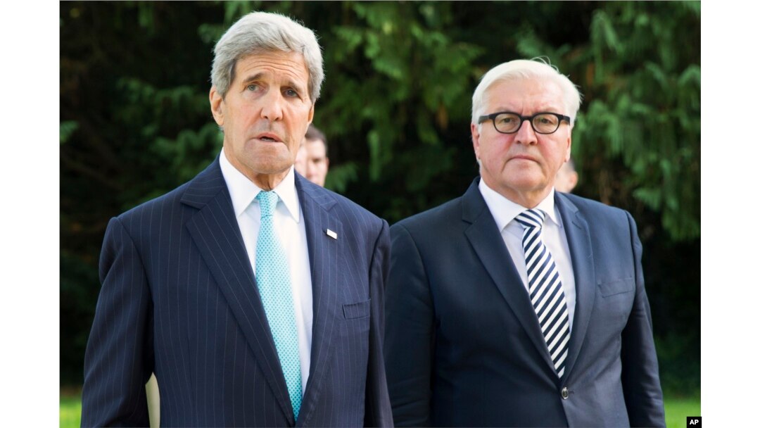 U.S. Secretary of State John Kerry, left, walks with German Foreign Minister Frank-Walter Steinmeier, prior to a meeting with a group of refugees fleeing Syria, at Villa Borsig, in Berlin, Sept. 20, 2015.