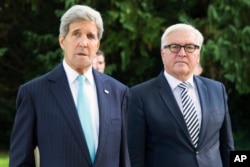 U.S. Secretary of State John Kerry, left, walks with German Foreign Minister Frank-Walter Steinmeier, prior to a meeting with a group of refugees fleeing Syria, at Villa Borsig, in Berlin, Sept. 20, 2015.