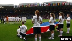 Children hold the North Korean flag ahead of the women's Group G football match between North Korea and Colombia at the London 2012 Olympic Games in Hampden Park, Glasgow, Scotland July 25, 2012.