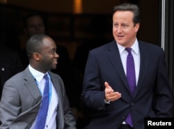 On Oct. 5, 2011, Britain's Prime Minister David Cameron, right, walks with Conservative MP Sam Gyimah on the final day of the Conservative Party's annual conference in Manchester, England.