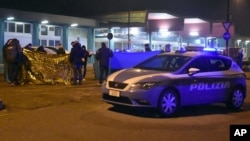 Italian police cordon off an area around a body after a shootout in the Sesto San Giovanni neighborhood of Milan, Italy, Dec. 23, 2016.