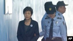 FILE - Former South Korean president Park Geun-hye, left, arrives to attend a hearing on the extension of her detention at the Seoul Central District Court in Seoul, South Korea, Oct. 10, 2017.