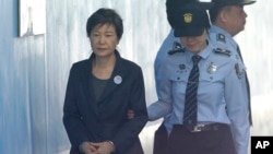 FILE - In this Oct. 10, 2017 file photo, Former South Korean President Park Geun-hye, left, arrives to attend a hearing on the extension of her detention at the Seoul Central District Court in Seoul, South Korea.